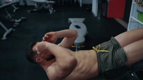 The attractive man performs sit ups at the gym. Intense masculine energy Stock Footage 156698203