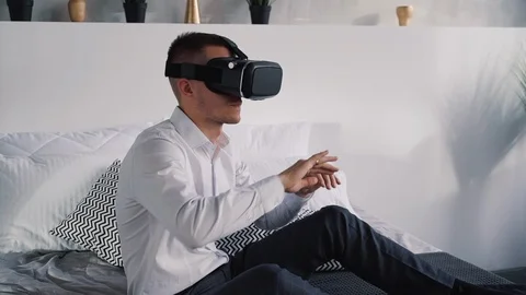 Attractive man playing at games in virtual reality helmet Stock Footage 110779881