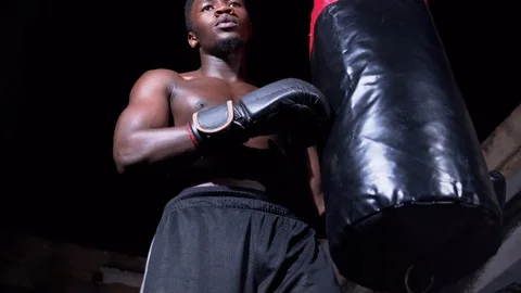 Attractive man posing on punching bag Stock Footage 115795921
