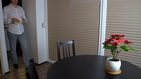 An attractive man prepares the table for his dinner and eats salad 库存影片 123229226