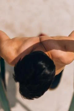 Attractive man pull-ups on a bar against blue sky Stock-Fotos