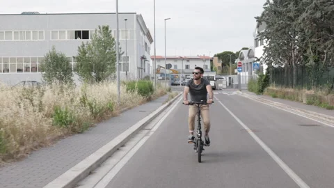 Attractive Man rides his foldable electric bike on the street and smiles Video stock 131407233