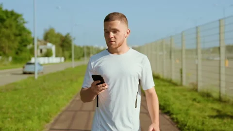 Attractive man runner stopped checks mail use phone feel happy and running Stock Footage 140365898