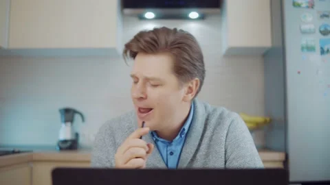 Attractive man singing while sitting at the computer at home Stock Footage 148341455