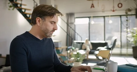 Attractive Man typing on Computer and drinking Coffee Stock Footage 86556127