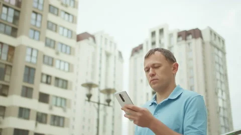 Attractive man typing text on a mobile phone, against the background Stock Footage 153688942