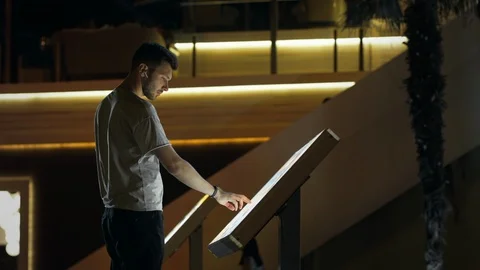 Attractive man using interactive touchscreen terminal display for searching info Stock Footage 107133473