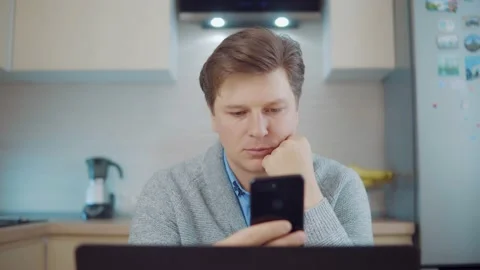 Attractive man using mobile phone at home Stock Footage 148339329