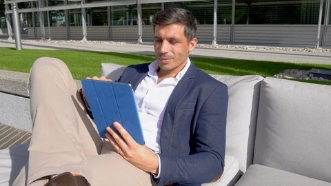 Attractive man using tablet outside, modern business 4K Stock Footage 96058265
