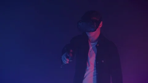 Attractive Man in Virtual Reality Glasses Draws Abstract Lines and Figures Using Stock Footage 121303074