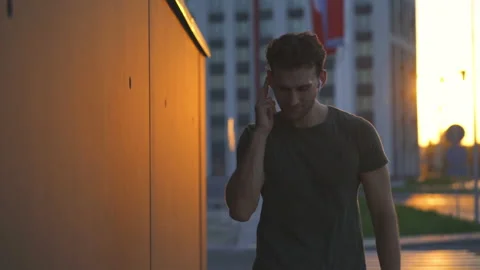 The attractive man walking and using airpods. slow motion Stock Footage 140629826