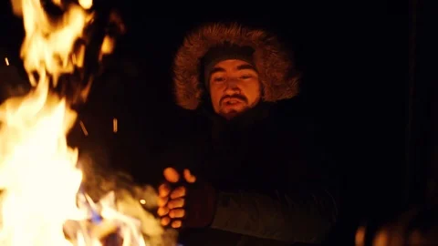 Attractive man warm hands an open fireplace outdoor at night happy in winter Stock Footage 105205026