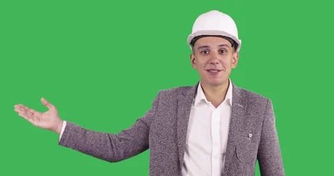 An attractive man in a white construction helmet and suit looks at the camera an Stock Footage 86232180