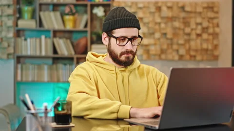 Attractive man working form his home office he typing something on his laptop Stock Footage 136549382