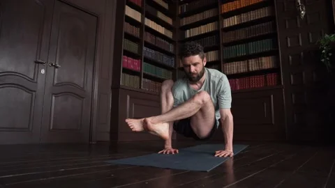 Attractive Man Yoga Instructor Performs Power Exercise At Home Stock Footage 152570107