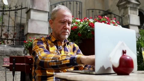Attractive mature bearded man using modern laptop outside enjoying sunny 스톡 동영상 163715322