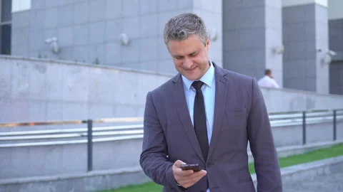 Attractive middle-aged man. Serious businessman looking into the phone, browsing Stock Footage 90914161