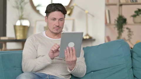 Attractive Middle Aged Man using Tablet, at Home Video stock 142369070