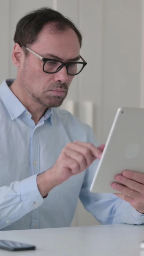 Attractive Middle Aged Man using Tablet in Office, Vertical Video 스톡 동영상 339585091