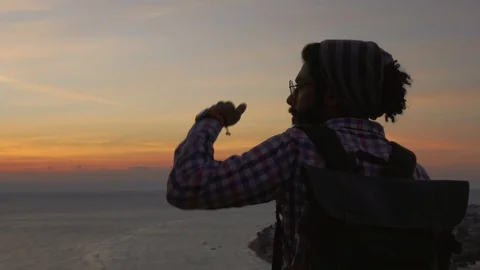 Attractive middle eastern male with dreadlocks looking ahead at sunrise Stock Footage 101370084