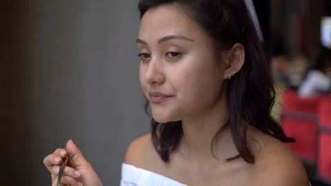 Attractive Mixed Girl Eats Cake with a Spoon and Smiles Enjoying it bokeh 4k Stock Footage 122991522
