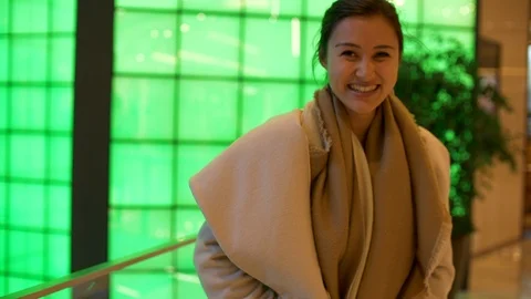 Attractive Mixed Girl Looks at Camera and her Phone and Laughs Colourful 4k Stock Footage 122992853