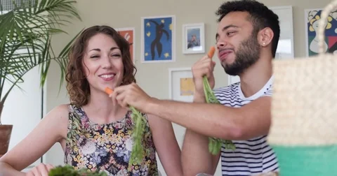 Attractive mixed race young couple preparing a healthy meal together. Vídeo Stock 80296384