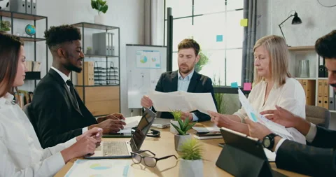 Attractive modern smart successful mixed race colleagues sitting at office table Stock Footage 159550256
