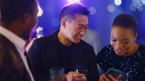 Attractive multi-ethnic friendly trio of corporate colleagues using mobile phone Stock Footage 147040958