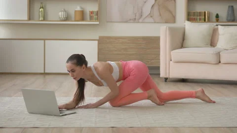 Attractive multi ethnic race lady looking laptop practice yoga online course at Stock Footage 148261644