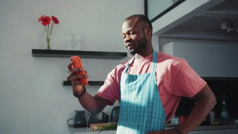 Attractive nice african man in cooking apron using smartphone making a video Stock Footage 131669899