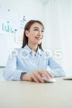 Attractive office worker sitting at desk Stock Photos