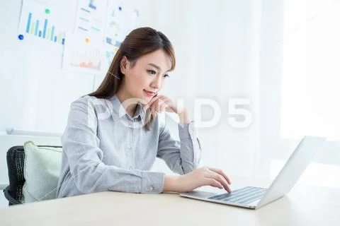 Attractive office worker sitting at desk Stock Photos