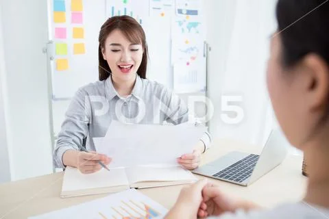 Attractive office worker sitting at desk Stock Photos