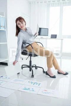 Attractive office worker working in office with orgnizing files on floor Stock Photos