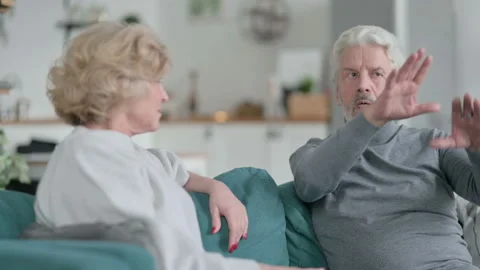 Attractive Old Man Talking to Beautiful Old Woman, Sitting on Sofa at home Stock Footage 148202078