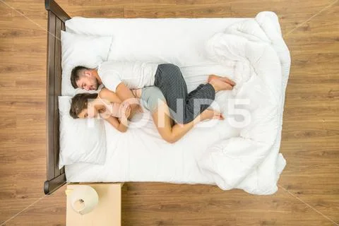 The attractive pair sleeping on the bed. View from above Stock Photos