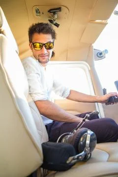 Attractive pilot sitting in the plane Stock Photos