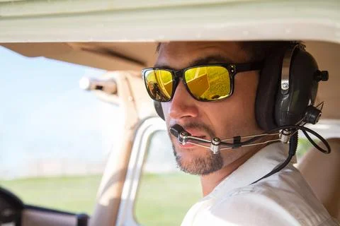 Attractive pilot sitting in the plane Stock Photos
