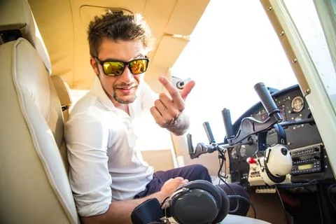 Attractive pilot sitting in the plane Stock Photos