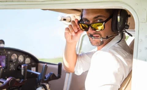 Attractive pilot sitting in the plane Stock Photos