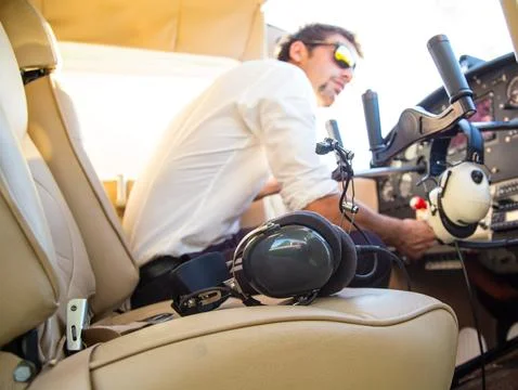 Attractive pilot sitting in the plane Stock Photos