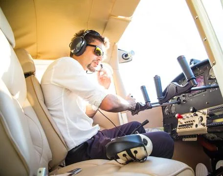 Attractive pilot sitting in the plane Stock Photos
