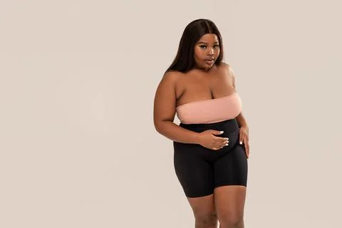 Attractive, plus size, dark skinned woman looking at the camera, posing in st Stock-Fotos