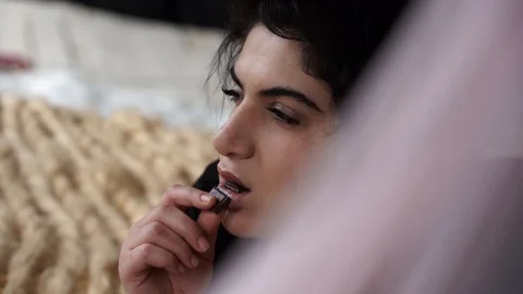 Attractive plus size model lying on bed eating chocolate Stock Footage 106070763