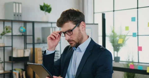 Attractive positive confident experienced bearded businessman working on tablet Stock Footage 159713450