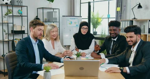 Attractive positive experienced mixed race businesspeople holding online Stock Footage 159666313