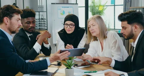 Attractive positive motivated experienced mixed race business colleagues sitting Stock Footage 159617142