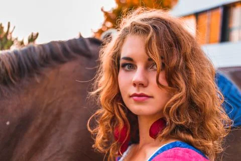 Attractive pretty redheaded, long-haired young girl looks at the camera close-up Stock Photos