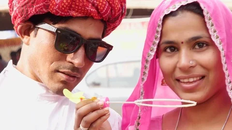 Attractive Rajasthani couple having fun blowing bubbles and wearing ethnic tradi Stock Footage 70283158